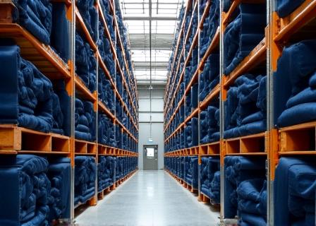 Stacked denim rolls in a clean, modern warehouse